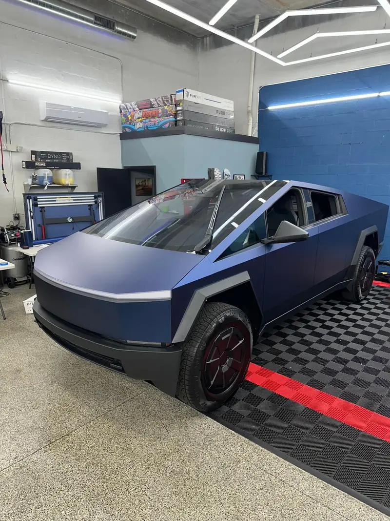 Tesla Cybertruck with a matte blue vinyl wrap in the Stealth Customs bay